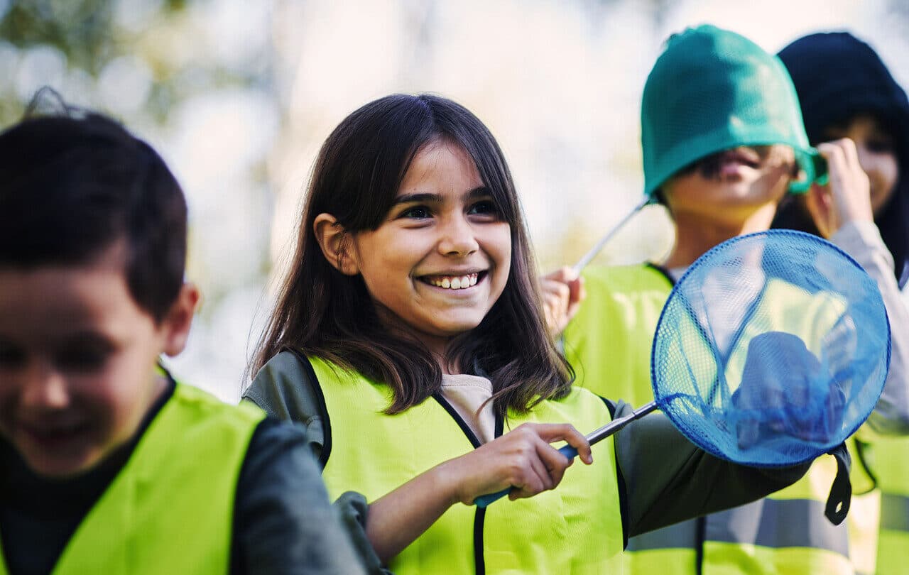 Elever med håv ute i naturen