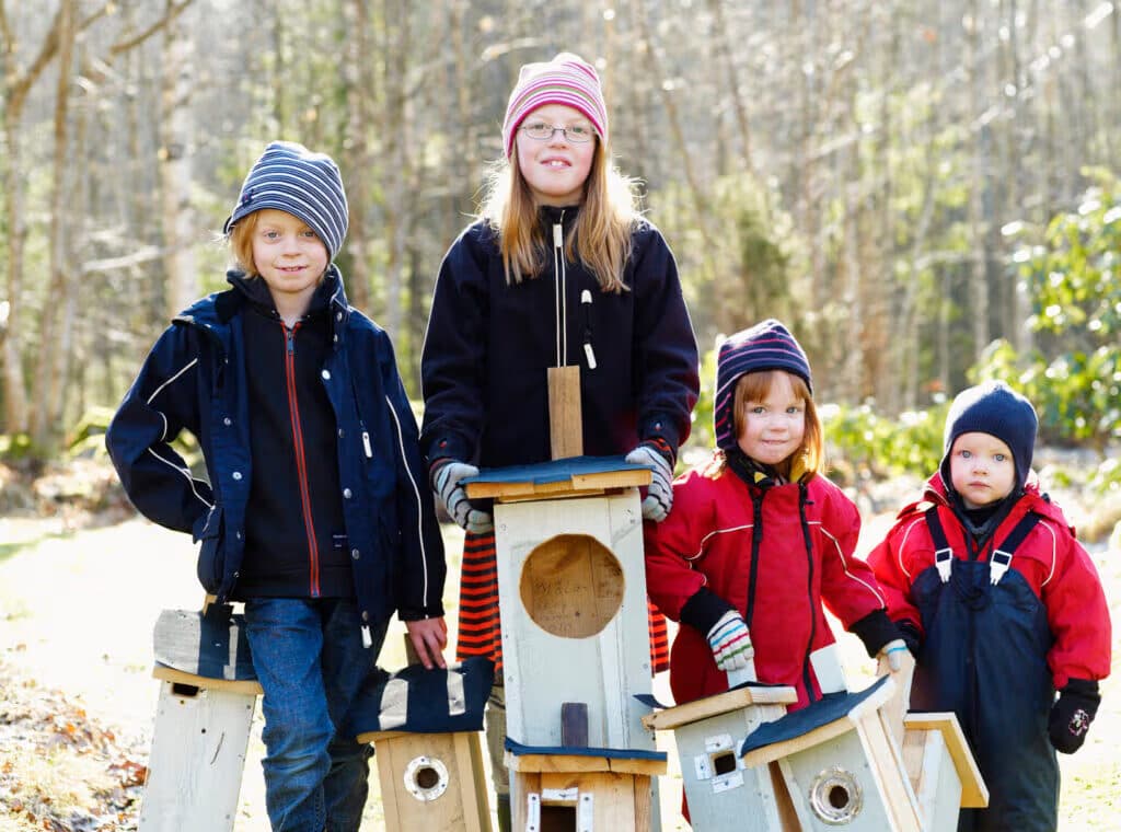Fyra barn står och håller i holkar och bon.