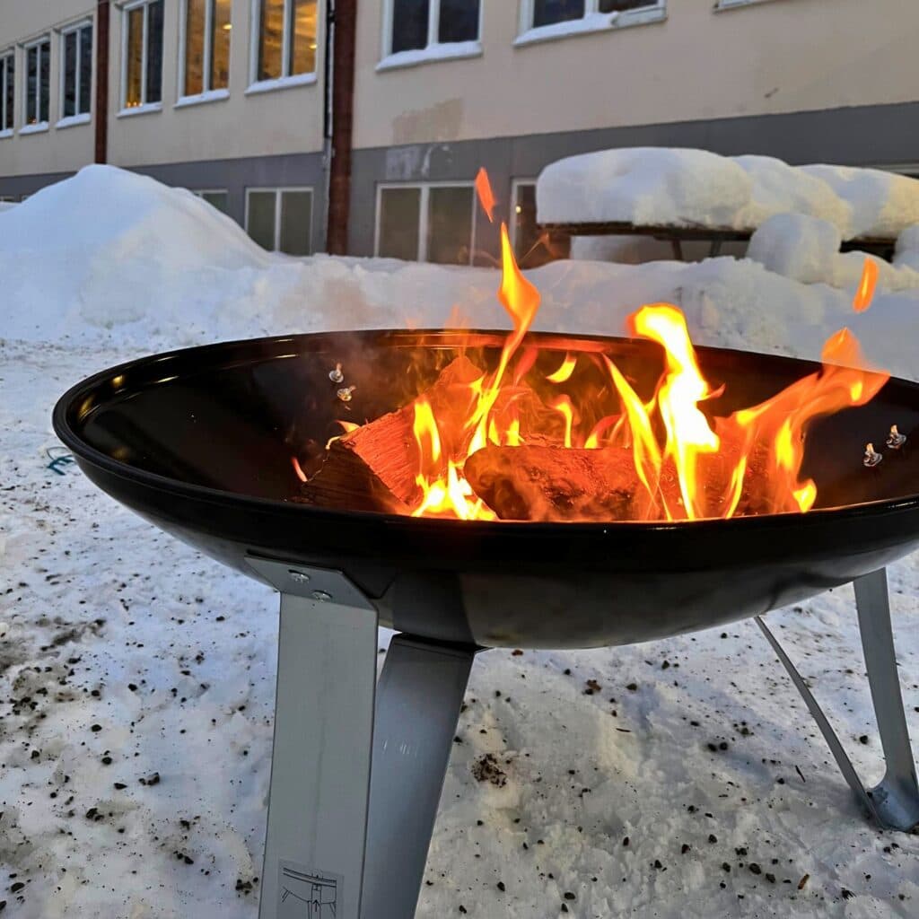 Eld på eldfat på en skolgård.